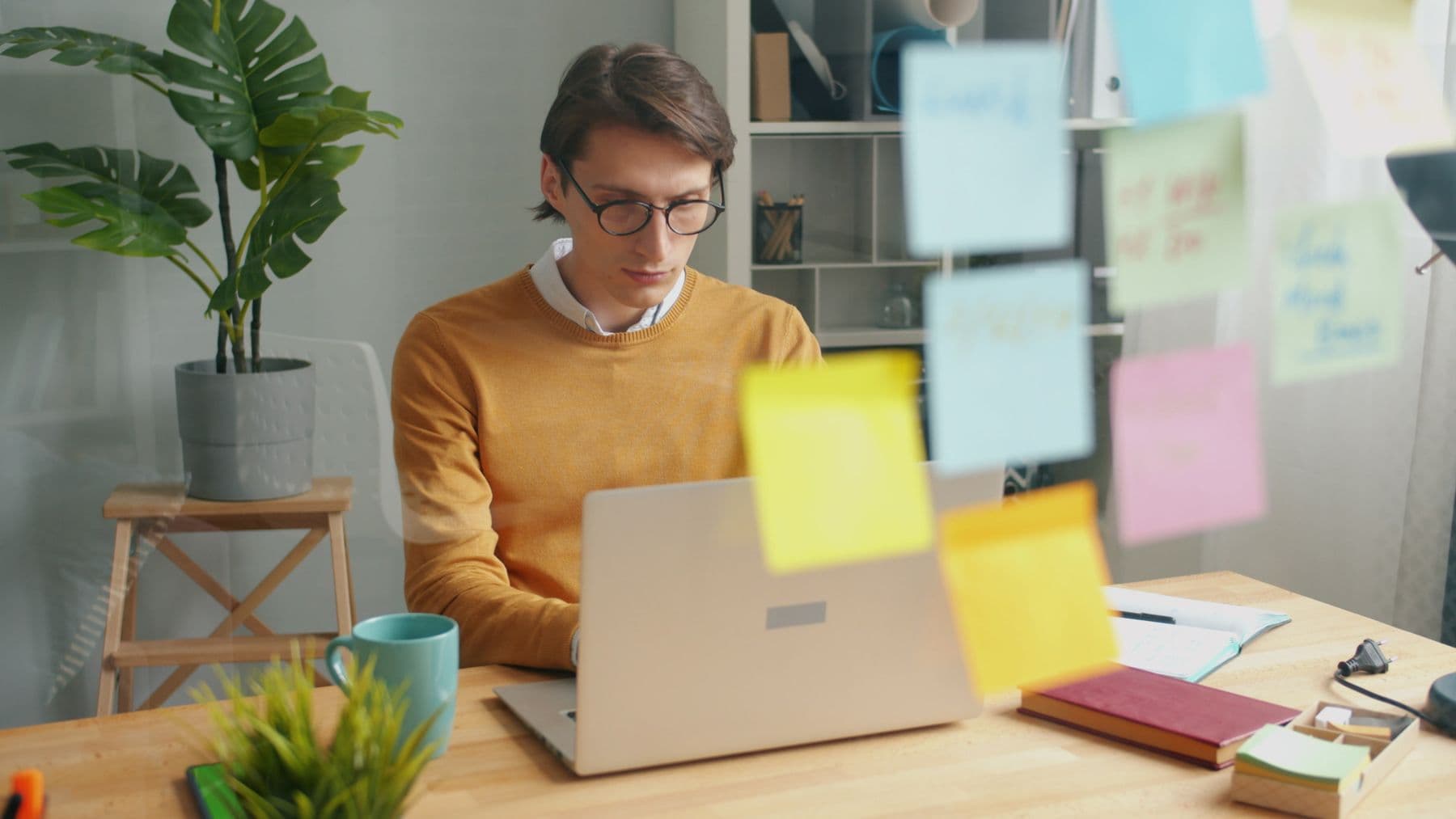 Un jeune professionnel organise ses tâches à l’aide de notes colorées